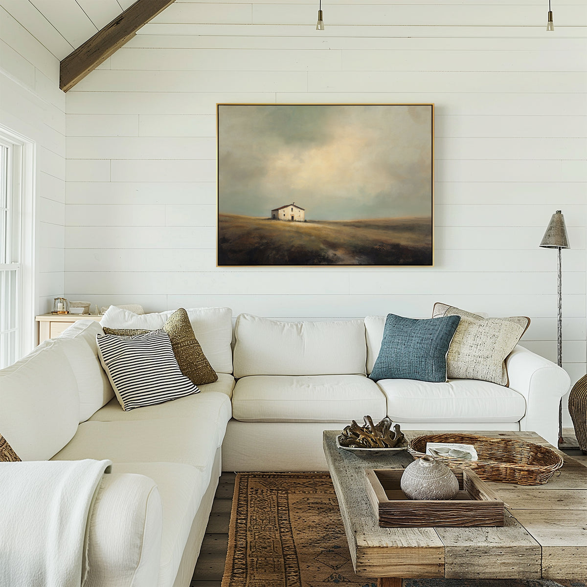 A cozy living room with a white sectional, assorted throw pillows, a rustic wood coffee table, and the Solitary House Canvas Art - Horizontal adding charm to weathered white farmhouse shiplap walls.