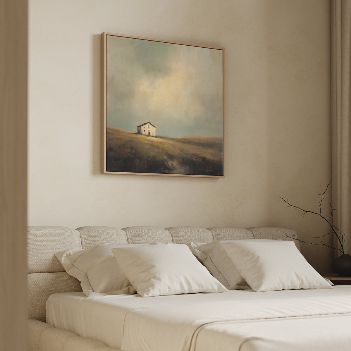 A minimal, neutral-toned bedroom features a beige upholstered bed with white bedding. Above the bed, the Solitary House Canvas Art - Square adds rustic charm with its image of a weathered white farmhouse on a grassy hill.