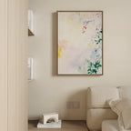 A minimal living room corner with a beige couch, light wood shelves, a small white décor piece, and the vibrant "Spring Reverie Canvas Art - Vertical" adding a splash of color to the space.