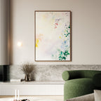 A modern living room highlights the Spring Reverie Canvas Art - Vertical with soft pastel tones above a low marble shelf, paired with a green curved sofa and a vase of dried branches for an inviting floral home decor touch.