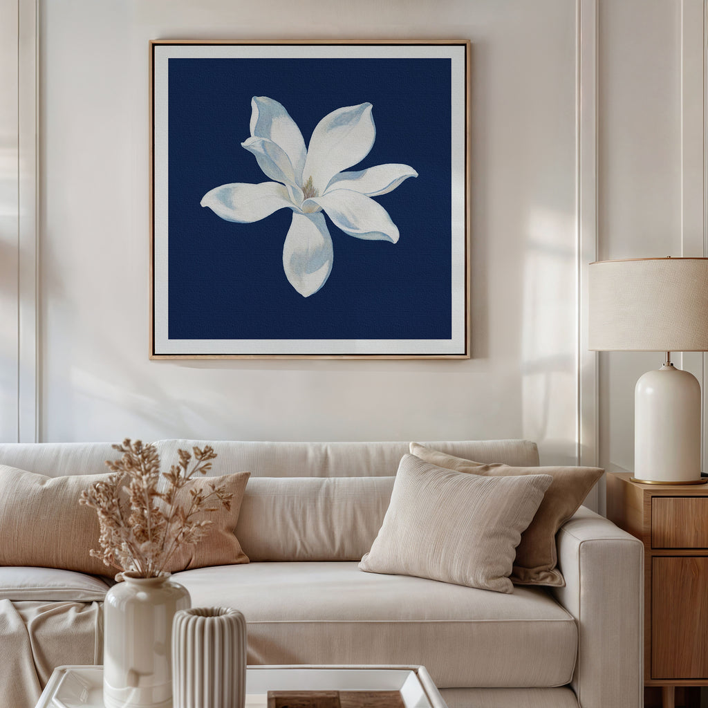 A modern living room with a beige sofa, neutral cushions, a side table with a lamp, and the Starlit Magnolia Canvas Art - Square hanging above the sofa adds elegant contemporary style to the space.