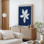 A modern living room features a light wood sideboard, neutral decor, and the Starlit Magnolia Canvas Art - Vertical as striking wall art. A potted plant and ceramic vases rest on the sideboard; a cream sofa sits in front.