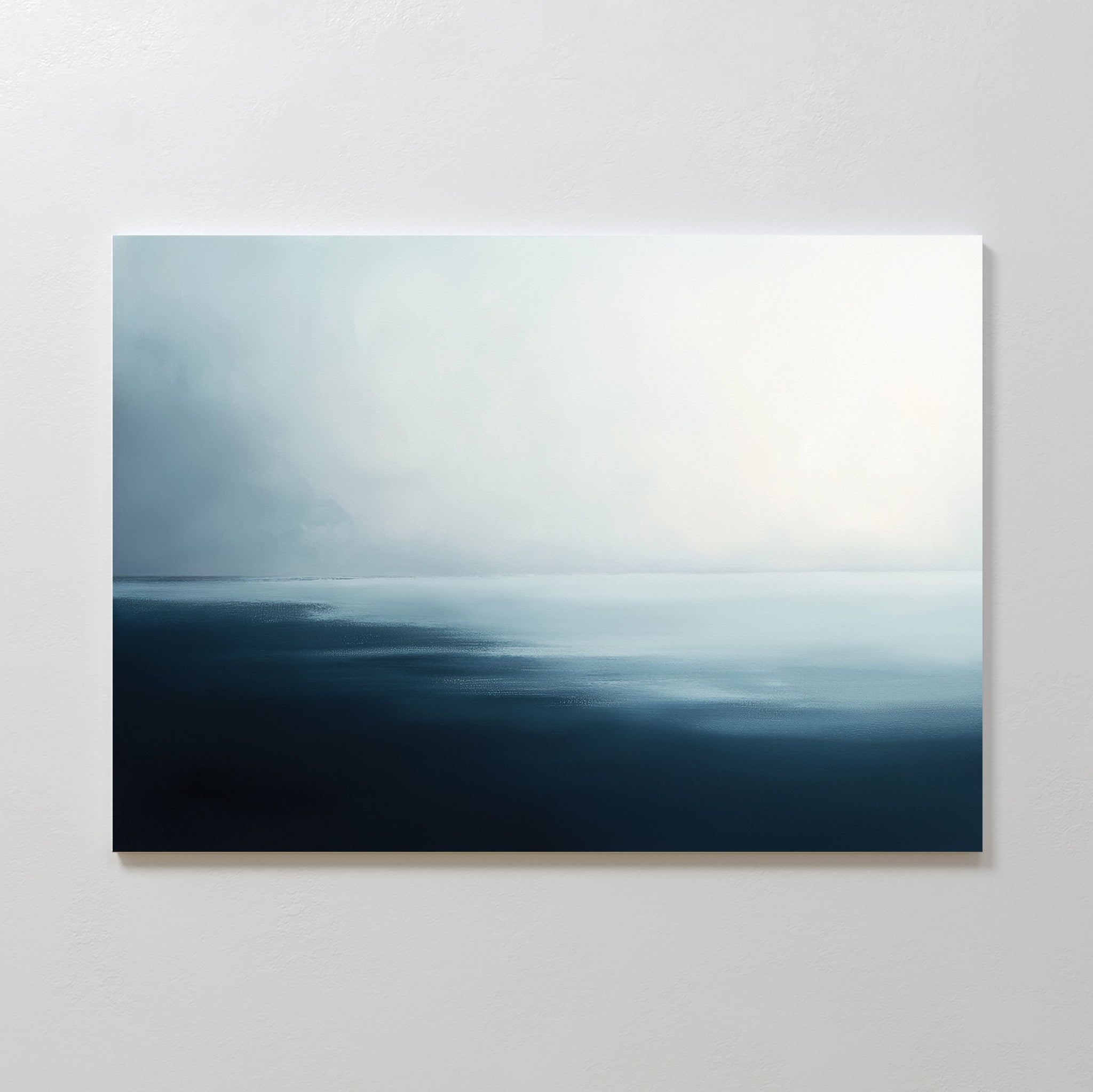 Steel Harbor Mist Canvas Art - Horizontal captures a minimalist seascape with dark blue water blending into soft white and gray skies, evoking Nordic Park tranquility. Displayed on a light wall, it brings serene vibes to any space.