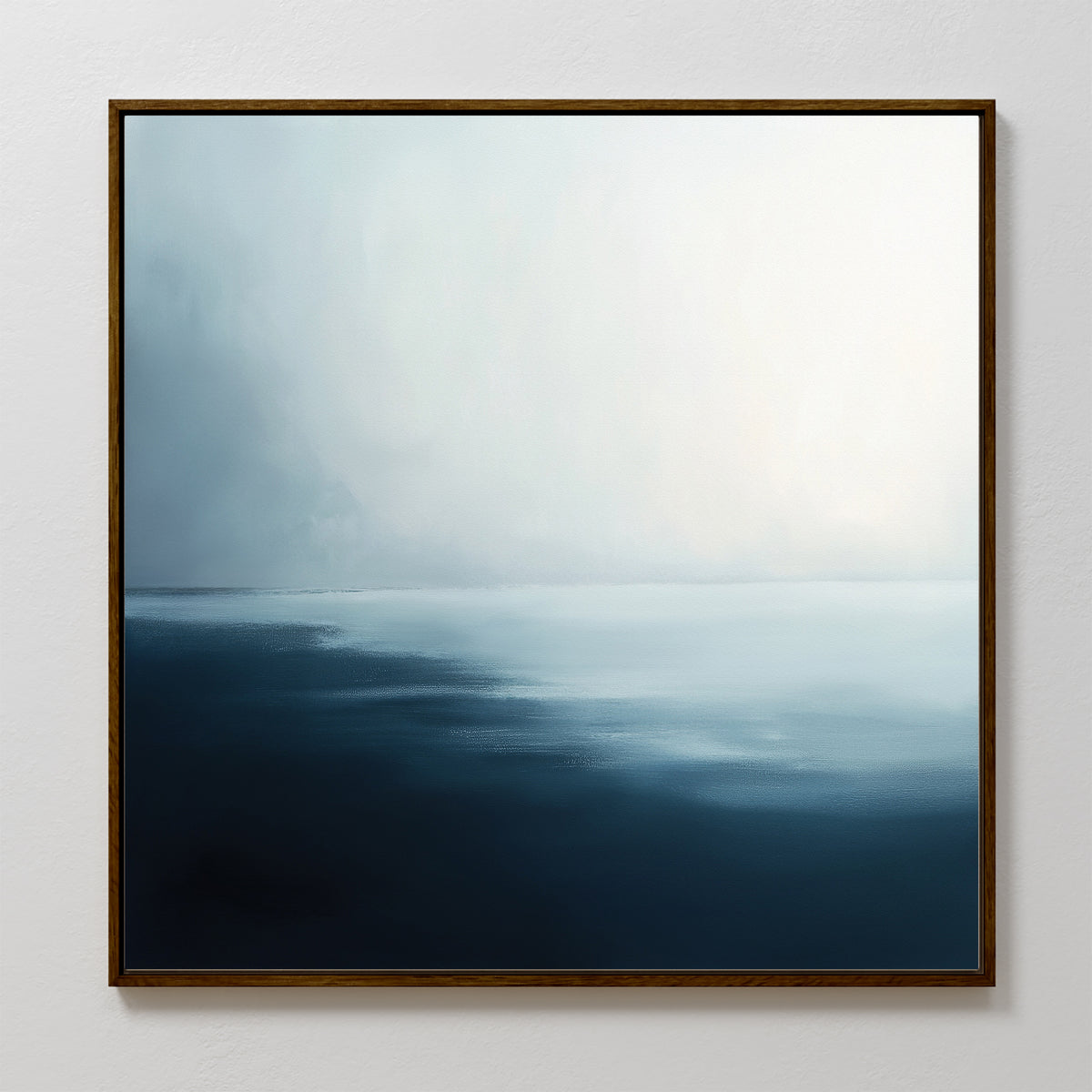 The Steel Harbor Mist Canvas Art - Square features a minimalist seascape in deep blue and soft mist tones, framed in dark wood, creating a calm atmosphere as it hangs on a plain white wall.