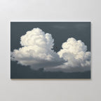The Storm Passage Canvas Art - Horizontal features two large, fluffy white clouds in a dark gray sky with a small airplane flying between them, displayed on a light-colored wall.