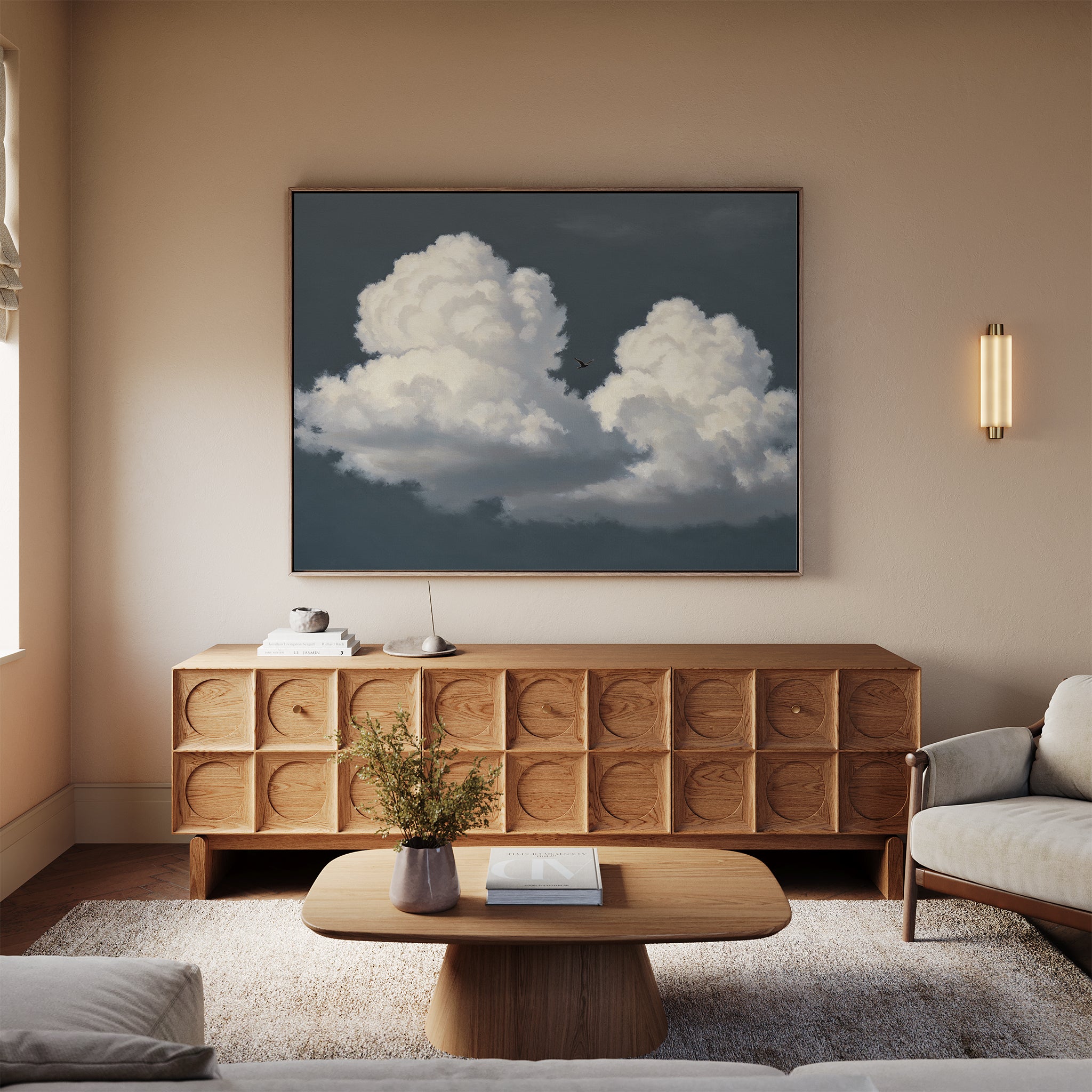 A cozy living room featuring the Storm Passage Canvas Art - Horizontal above a wooden sideboard, a modern coffee table, beige sofa, and a small vase with flowers. Warm lighting highlights the neutral decor.