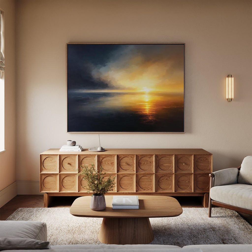 A cozy living room with a beige sofa, light wood coffee table, and textured wood sideboard. Above the sideboard hangs the Storm's Edge Canvas Art - Horizontal, while a modern wall sconce provides soft lighting.