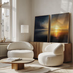 A modern living room with two white armchairs, a low wood coffee table, a floor lamp, and Storm's Edge - Set of 2 canvas prints leaning against a wooden sideboard by the window.
