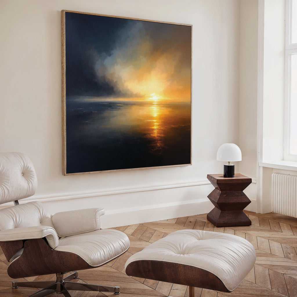 A modern living room with a leather lounge chair and ottoman, a small wooden side table with a white lamp, and Storm's Edge Canvas Art - Square—an atmospheric large canvas print—hanging on the wall.