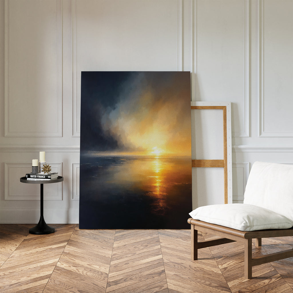 The Storm's Edge Canvas Art - Vertical, featuring a dramatic sunset over water, leans against a white paneled wall in a modern room with herringbone wood floors, a cushioned chair, and a black table with candles and books.