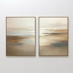 The "Sunlit Waters - Set Of 2" features framed abstract prints with soft beige, brown, and white tones that evoke a tranquil, misty landscape. Both pieces are displayed side by side on a plain white wall.
