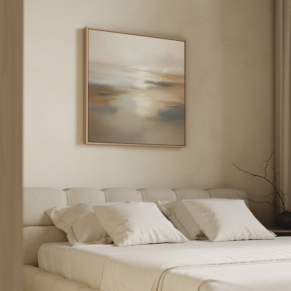 A modern beige bedroom with a low upholstered bed, white bedding, and three pillows. Above the bed hangs the Sunlit Waters Canvas Art - Square print. A twig in a vase decorates the right bedside table.