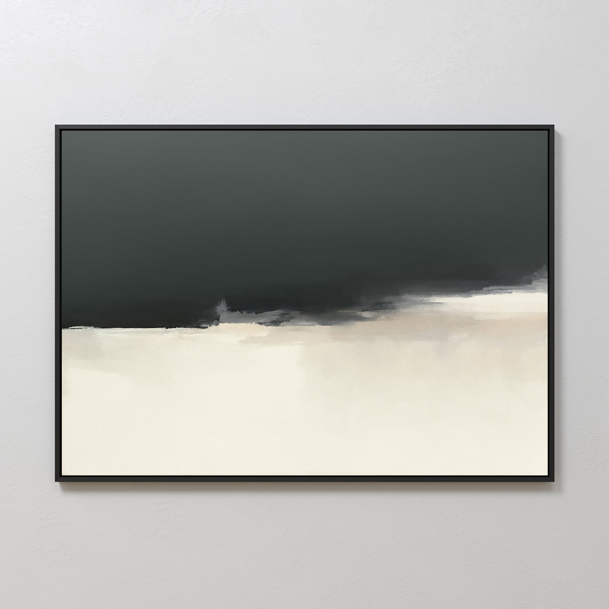 The Tempest Brewing Canvas Art - Horizontal features a minimalist abstract design with a dark gray upper half merging into beige and white below, framed in black and displayed on a light-colored wall as striking modern decor.