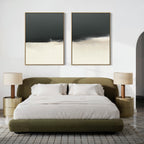 A modern bedroom with a green upholstered bed, white bedding, two gold nightstands with pleated lamps, and the Tempest Brewing - Set Of 2—large abstract black, white, and beige paintings—creating an atmospheric scene above the headboard.