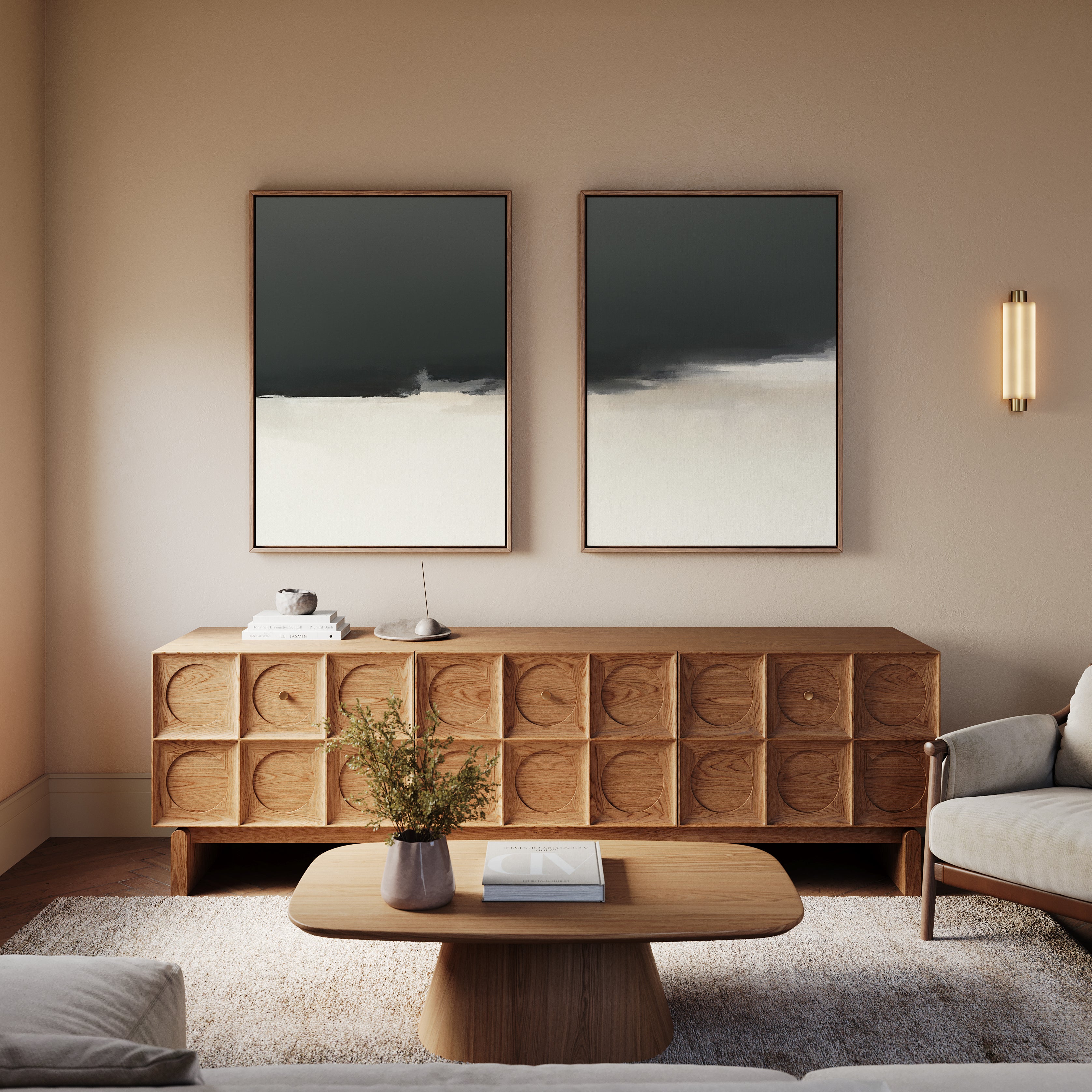 A modern living room with a wooden sideboard, light sofa, and dramatic wall art. The Tempest Brewing - Set Of 2 abstract paintings add atmosphere above a coffee table with greenery, while a wall sconce completes the scene.