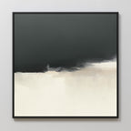 Tempest Brewing Canvas Art - Square features a minimalist abstract design with black blending into white and beige tones. Framed in a simple black frame, this moody wall art is shown hung on a light gray wall.
