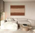 A minimalist living room with a light beige sectional, wooden coffee table with a black bowl, potted plant, and Terracotta Currents Canvas Art - Horizontal on the wall. Natural light filters through sheer curtains.