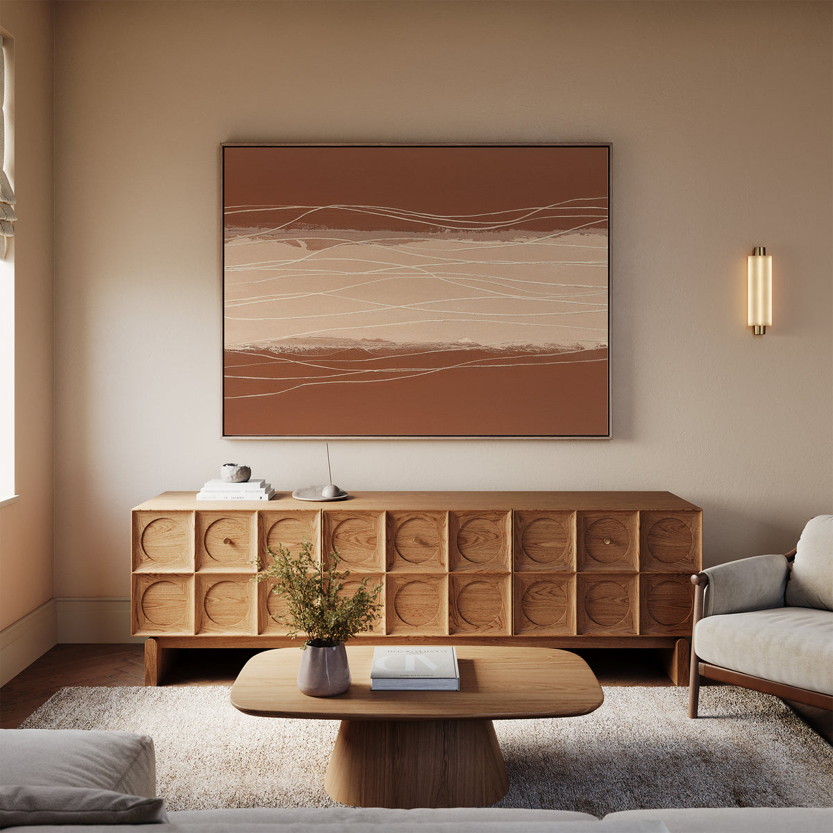 Minimalist living room with light walls, a wooden sideboard, and Terracotta Currents Canvas Art - Horizontal above a beige sofa. A round coffee table with a vase of flowers, rug, and modern wall sconce complete the look.