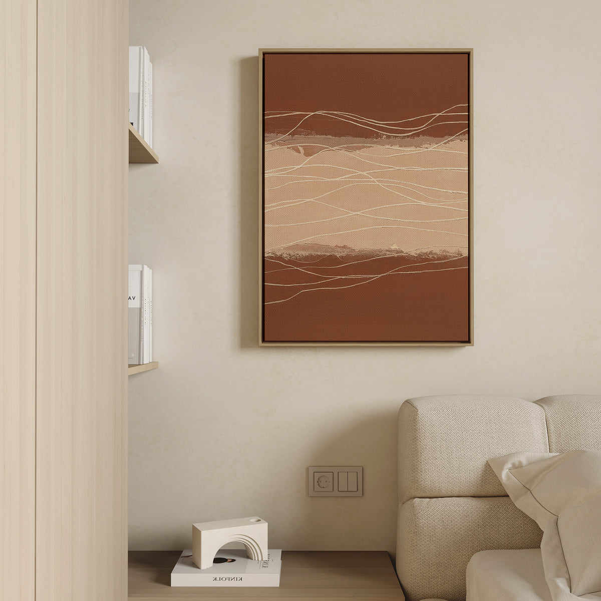 A minimalist living space features a beige sofa, a small white geometric object on a wooden floor, shelves with books, and the Terracotta Currents Canvas Art - Vertical in warm brown and beige tones hanging on the wall.