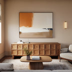 A modern living room featuring a wooden sideboard, the Terracotta Edge Canvas Art - Horizontal above it, a round wooden coffee table with a book and vase, neutral furniture, and warm lighting for inviting decor.