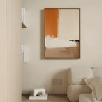 A modern living room decor with a beige sofa, books on a wooden shelf, and the Terracotta Edge Canvas Art - Vertical in orange, beige, and black on a light wall. A small white decorative item rests on the floor.