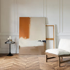 A minimalist room with herringbone wood floors, a white cushioned chair, black round table, and two Terracotta Edge Canvas Art - Vertical prints leaning against a white paneled wall.