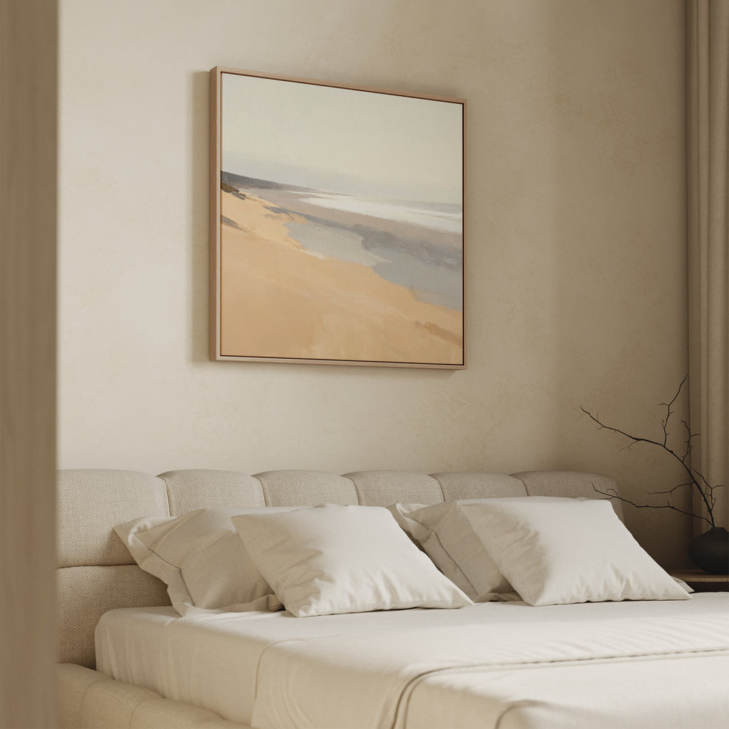 A minimal bedroom with a beige upholstered bed, white bedding, and pillows. Above the bed hangs the Tidal Meditation Canvas Art - Square in soothing earth tones. A bare branch decorates a vase on the bedside table.