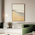 A modern living room with a green upholstered chair, marble-topped shelf, dried flowers in a vase, and "Tidal Meditation Canvas Art - Vertical"—a large framed abstract beach scene—hanging on a light-colored wall.