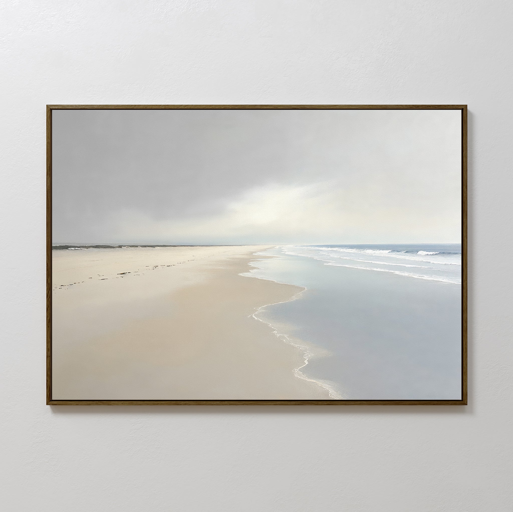 The Tidal Reflections Canvas Art - Horizontal, featuring a serene beach with gentle waves, wet sand, and a cloudy sky, hangs on a plain white wall—an ideal piece of calming coastal wall decor with distant horizon and faint shore footprints.