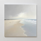 Bring tranquility to your space with the Tidal Reflections Canvas Art - Square, featuring an empty beach, gentle waves, soft cloudy skies, and footprints leading to the horizon in soothing pastel tones.