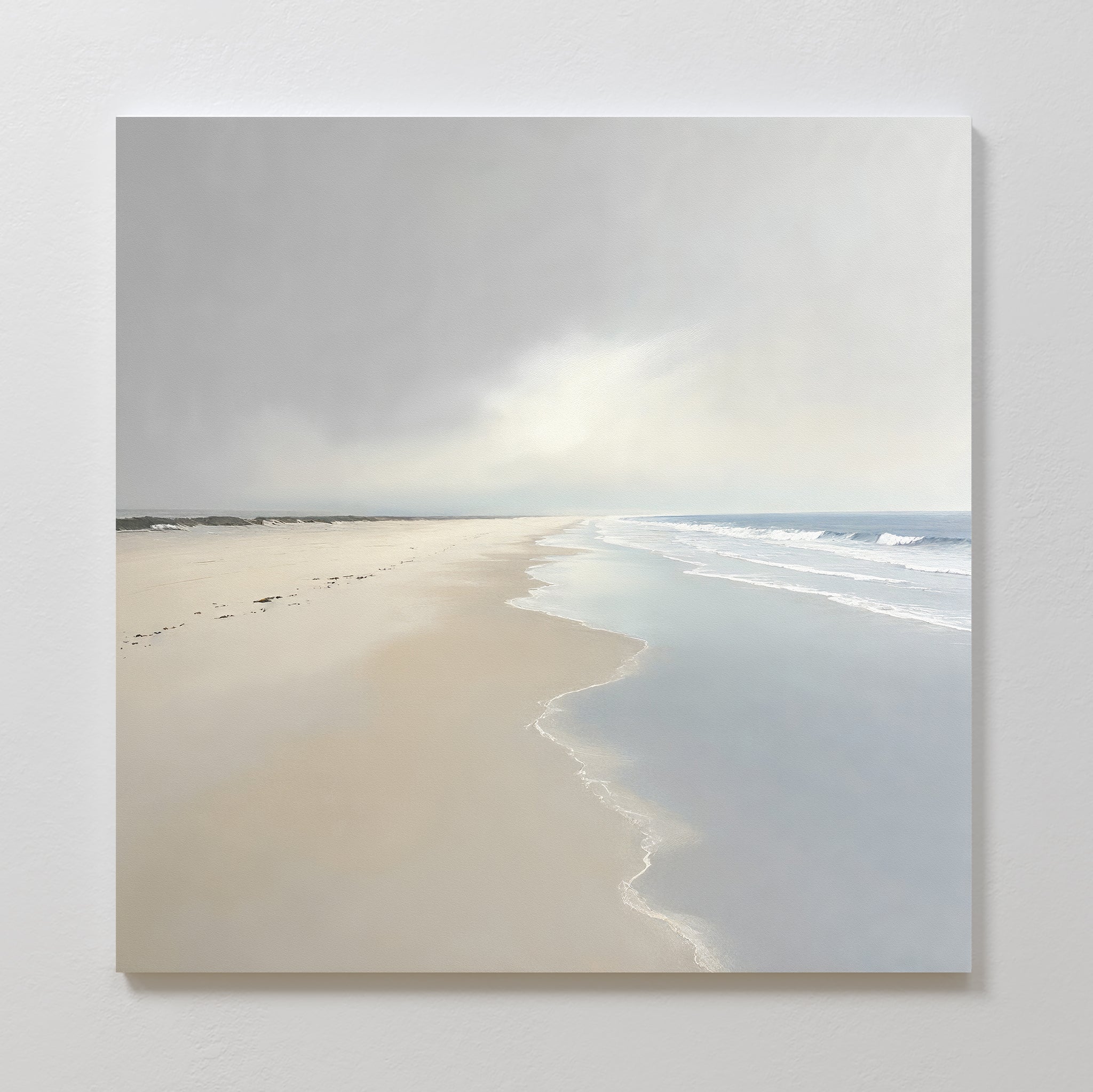 Bring tranquility to your space with the Tidal Reflections Canvas Art - Square, featuring an empty beach, gentle waves, soft cloudy skies, and footprints leading to the horizon in soothing pastel tones.