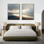 A modern bedroom with a green upholstered bed, white bedding, and round nightstands with beige lamps. Above the bed, the Tidal Reverie - Set of 2 wall art creates calm, while a textured rug on the floor adds comfort.