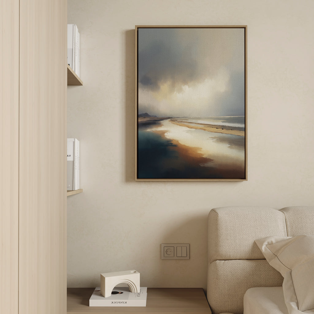 The Tidal Reverie Canvas Art - Vertical, featuring a serene seascape with sunlit water and cloudy skies, hangs above a light sofa in this minimalist living room. White books and a geometric sculpture accent nearby shelves for an elegant coastal feel.