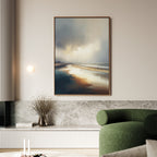 A modern living room with a green curved sofa, marble accent wall, minimalist light fixture, and the Tidal Reverie Canvas Art - Vertical—a large beach landscape print—hangs above a low shelf displaying a vase and books.