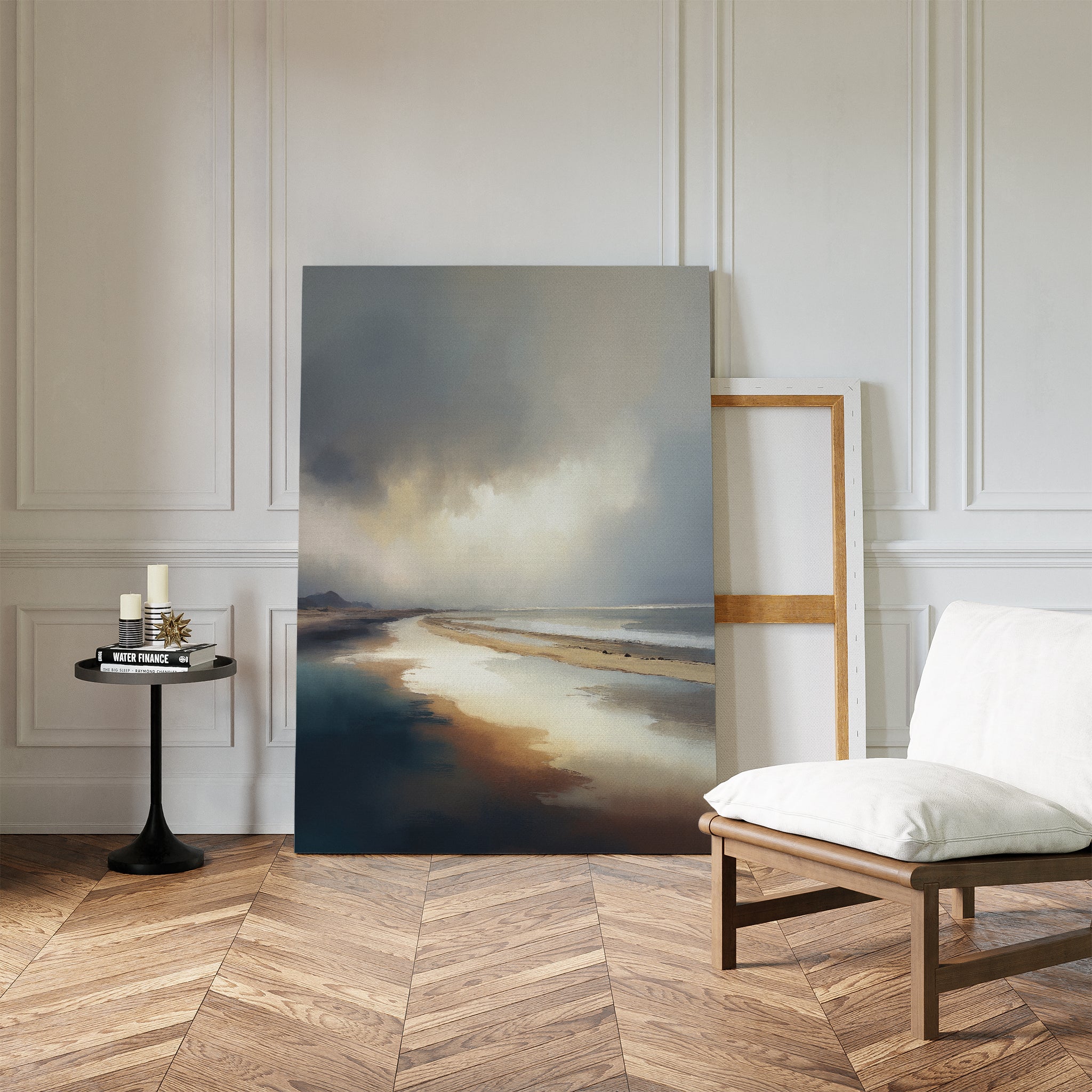 The Tidal Reverie Canvas Art - Vertical rests against a white paneled wall in a minimalist room with herringbone wood floors, a cushioned chair, a small black side table with candles, and an empty picture frame.