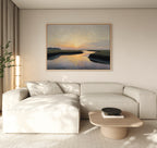 A modern living room with a beige sectional sofa, light wood coffee table, and the Tidal Whispers Canvas Art - Horizontal of a coastal marsh hanging above the couch. A tall plant in the corner completes the peaceful home decor.