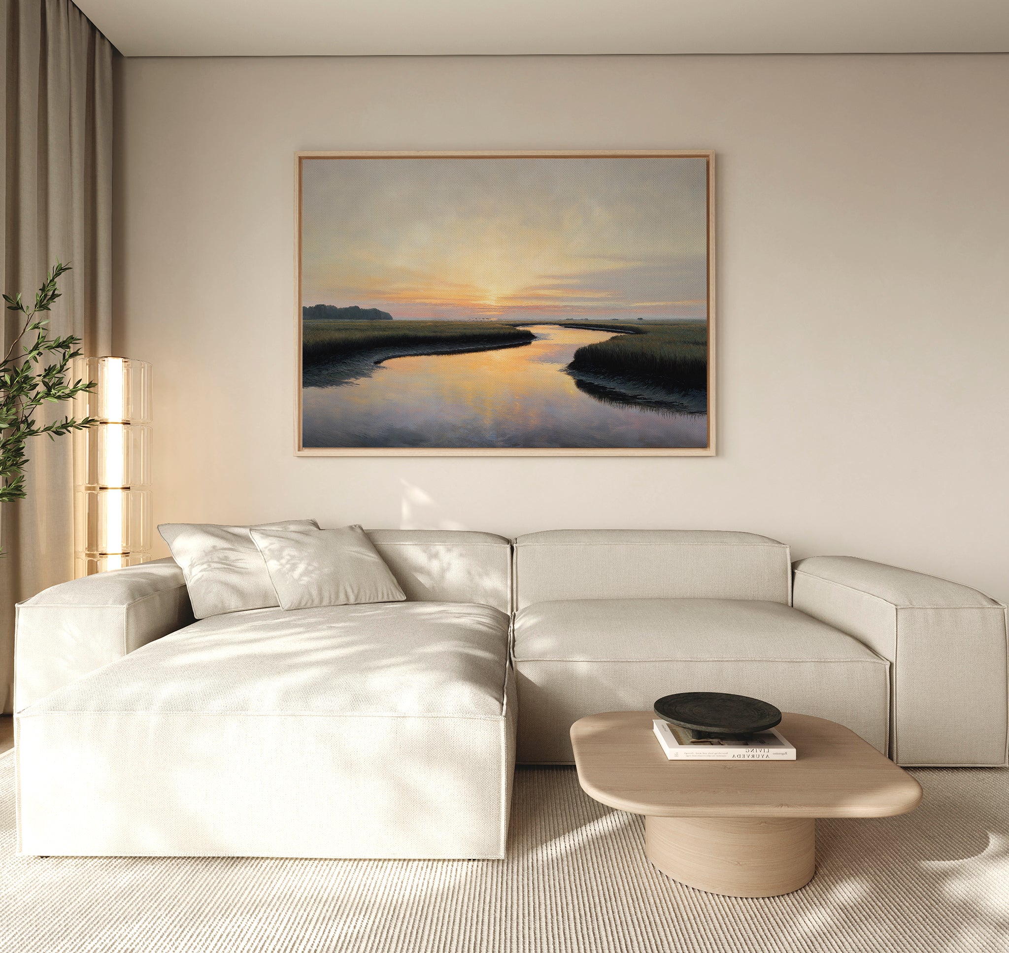 A modern living room with a beige sectional sofa, light wood coffee table, and the Tidal Whispers Canvas Art - Horizontal of a coastal marsh hanging above the couch. A tall plant in the corner completes the peaceful home decor.