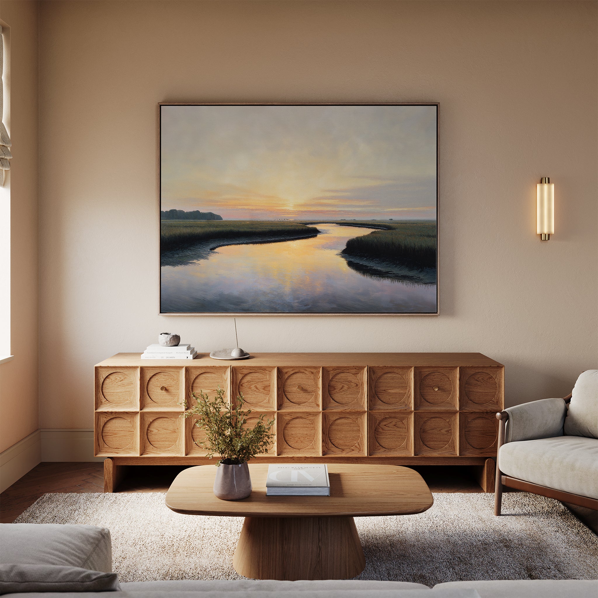 A cozy living room with neutral tones features a wooden sideboard, a coffee table with flowers, and the Tidal Whispers Canvas Art - Horizontal above the sofa. Modern sconces and peaceful decor complete this calm, inviting space.