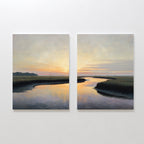 Tidal Whispers - Set of 2 features a serene marsh at sunset on canvas. Soft orange and blue skies reflect in winding water among tall grasses, with distant trees silhouetted for stunning coastal wall art.