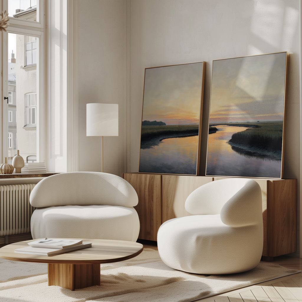 A room with white chairs, a table, and sunset artwork feels warm, while the "Tidal Whispers - Set of 2" coastal marsh wall art adds a serene atmosphere.