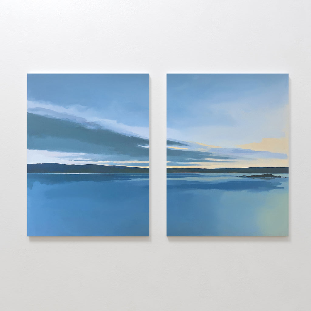 The Tranquil Reflections - Set of 2 features two calm blue seascapes with dark horizons and soft clouds fading to pale yellow, bringing serene Nordic Park-inspired beauty into your space as a tranquil canvas print.