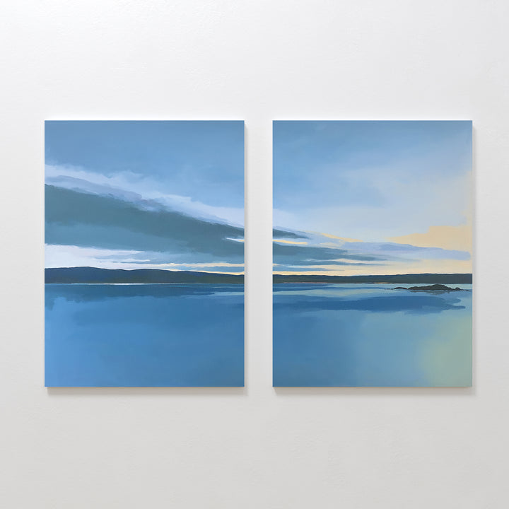 The Tranquil Reflections - Set of 2 features two calm blue seascapes with dark horizons and soft clouds fading to pale yellow, bringing serene Nordic Park-inspired beauty into your space as a tranquil canvas print.