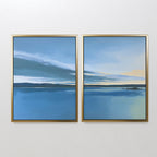 The Tranquil Reflections - Set of 2 features framed paintings of a serene blue lake, distant land, and subtle clouds with yellow accents, bringing peaceful ambiance and elegance to any space.