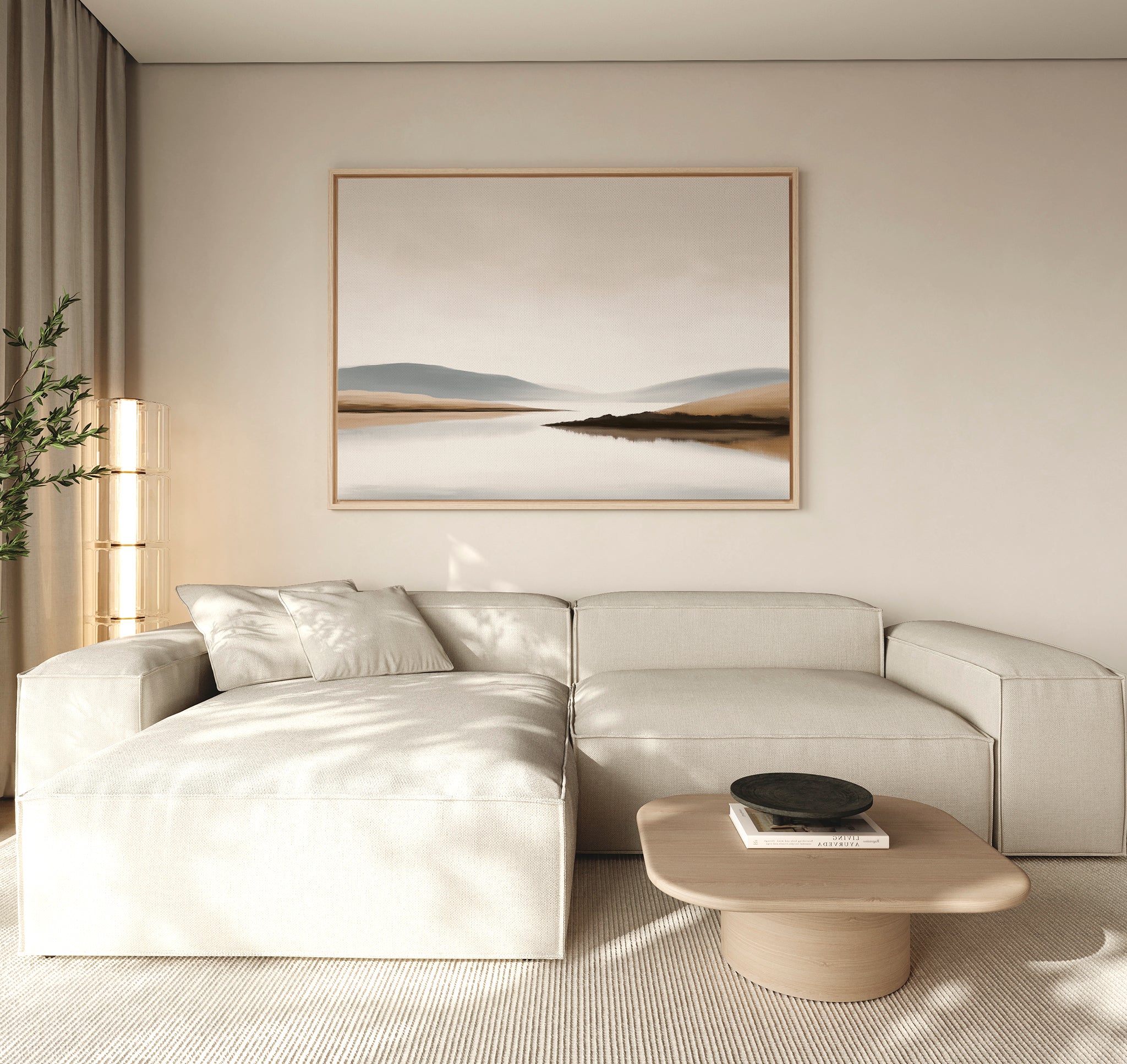 A modern living room features a light beige sectional sofa, low wooden coffee table, black decorative bowl, tall plant, and the Tranquil Waters Canvas Art - Horizontal depicting a misty lakeside landscape on the wall.