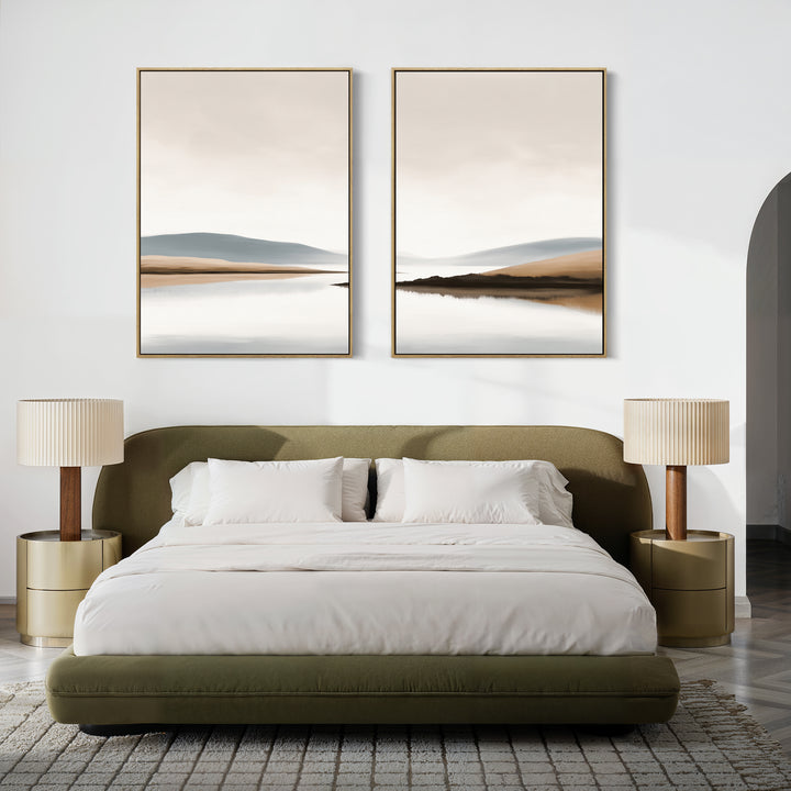 A modern bedroom featuring an olive green upholstered bed, white bedding, beige lamps on round nightstands, a gray textured rug, and "Tranquil Waters - Set of 2" minimalist misty lakeside landscape canvas prints above the bed.