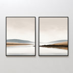 Tranquil Waters - Set of 2 features framed minimalist lakeside landscape prints with calm water, distant hills, and a neutral sky. These serene wall art pieces create a seamless, peaceful scene when displayed side by side.
