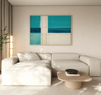 A modern living room featuring a light beige sectional, a low wooden coffee table with a black bowl, a tall plant, and the Turquoise Grid Canvas Art - Horizontal as contemporary abstract wall art above the sofa.