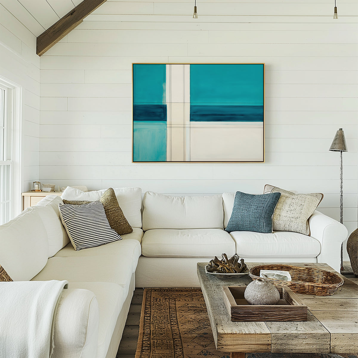 A cozy modern living room decor with a white sectional, blue and neutral pillows, a rustic wood coffee table, and the Turquoise Grid Canvas Art - Horizontal on a shiplap wall, all bathed in warm natural light.
