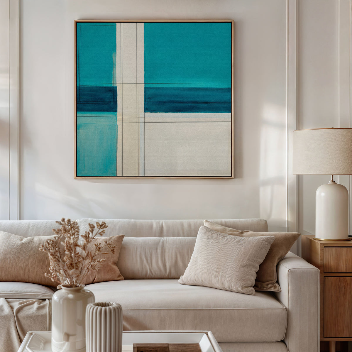 A modern living room with a beige sofa, light cushions, a side table with a ceramic lamp, and a vase of dried flowers. Above the sofa, the Turquoise Grid Canvas Art - Square adds striking contemporary flair as wall decor.