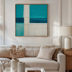 A modern living room with a beige sofa, light cushions, a side table with a ceramic lamp, and a vase of dried flowers. Above the sofa, the Turquoise Grid Canvas Art - Square adds striking contemporary flair as wall decor.